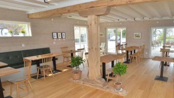 Ein Esszimmer mit vielen Holztischen und Stühlen