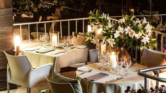 Ein Tisch mit Kerzen und Blumen in einer Vase