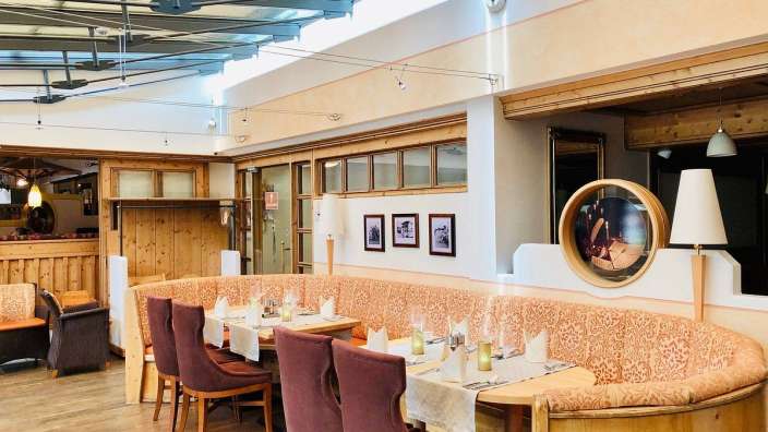 Ein Restaurant mit einem Tisch und Stühlen und Bildern an der Wand