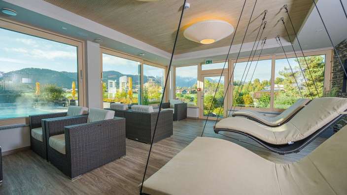 Ein Raum mit Liegestühlen und Stühlen mit Blick auf die Berge