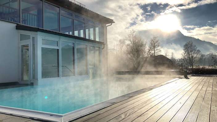 Ein schwimmbad mit einem gebäude im hintergrund