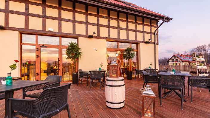 Eine Terrasse mit Tisch und Stühlen vor einem Gebäude