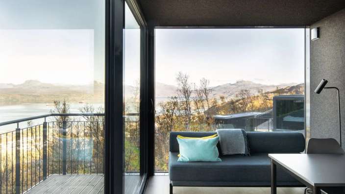 Ein Wohnzimmer mit einer Couch und einem Tisch mit Blick auf einen See