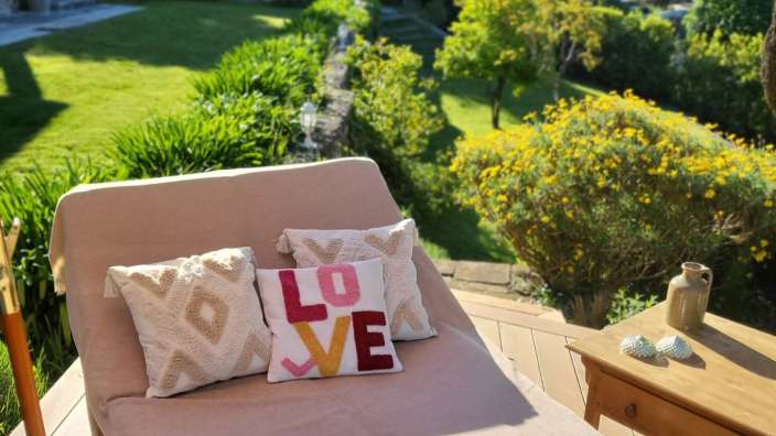 Auf einem Liegestuhl sitzt ein Kissen mit der Aufschrift love