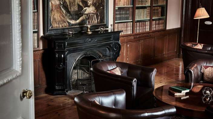 Ein Wohnzimmer mit Ledersesseln und einem Kamin