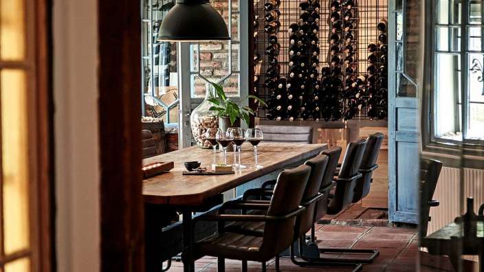 Ein Esszimmer mit einem Tisch und Stühlen und vielen Weingläsern