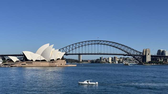 Ein weißes Boot fährt in der Nähe des australischen Opernhauss