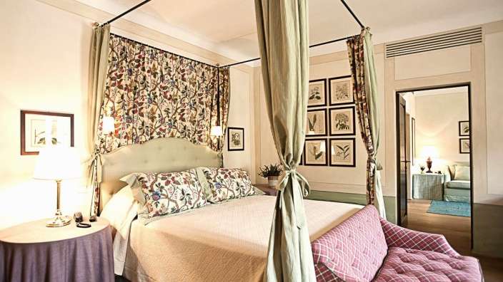 Ein Schlafzimmer mit einem Himmelbett und einer Couch