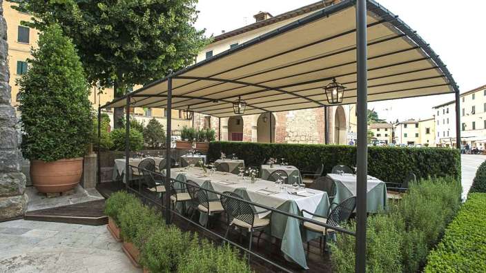 Ein Restaurant mit Tisch und Stühlen unter einem Zelt