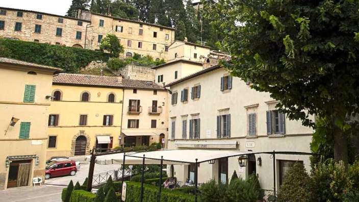 Eine Gruppe von Menschen sitzt vor einem Restaurant mit einem weißen Dach