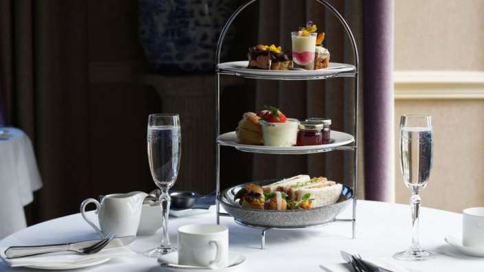 Auf einem weißen tisch steht ein teller mit sandwiches und desserts