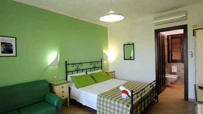 Ein Schlafzimmer mit grünen Wänden und einem Bett