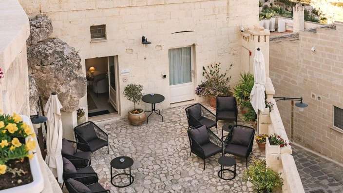 Eine Terrasse mit Stühlen und Tischen vor einem Gebäude