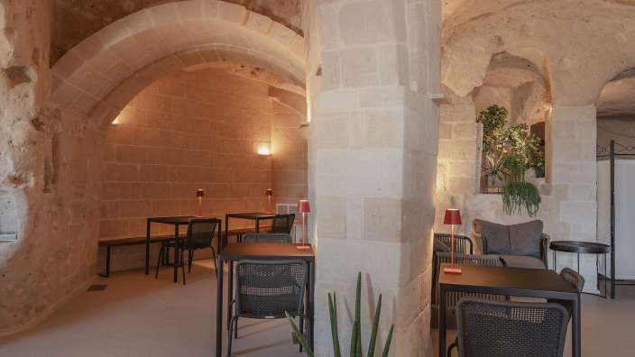 Eine Reihe von Tischen und Stühlen in einem Raum mit Steinsäulen