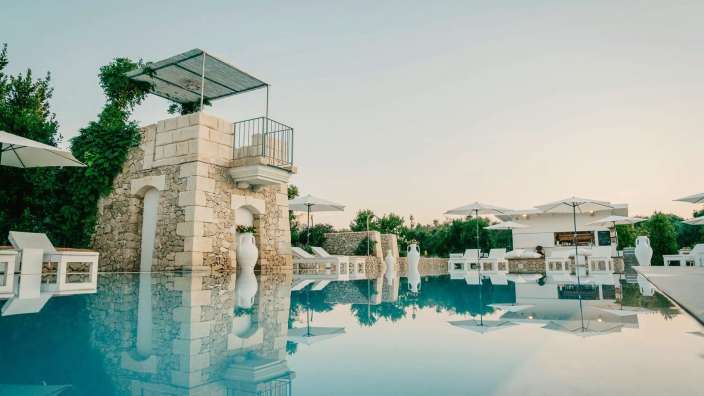 Ein großer Pool mit einem weißen Gebäude im Hintergrund