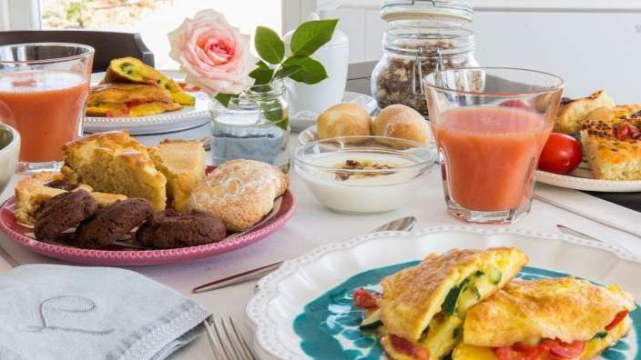 Ein Tisch mit verschiedenen Speisen und Getränken sowie einem Handtuch mit dem Buchstaben r darauf