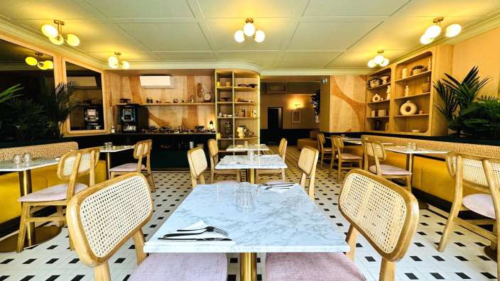 Ein Restaurant mit Tisch und Stühlen und einem schwarz-weißen Fliesenboden