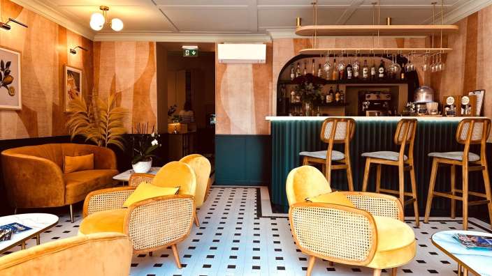 Ein Wohnzimmer mit gelben Stühlen und einer Bar