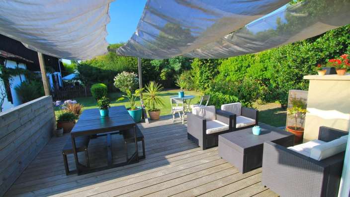 Eine Terrasse mit einem Tisch und Stühlen und einer weißen Decke