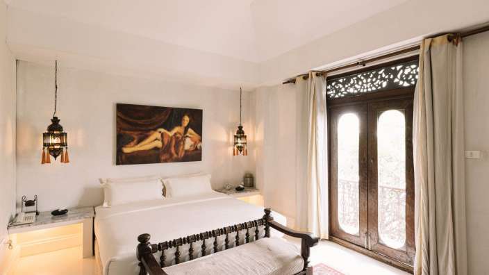 Ein Schlafzimmer mit einem Bett und einem Gemälde an der Decke