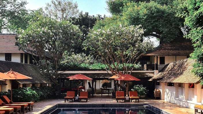 Ein großer Swimmingpool umgeben von Stühlen und Regenschirmen