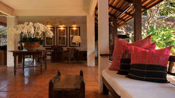 Ein Wohnzimmer mit vielen Kissen und einem Tisch mit Blumen