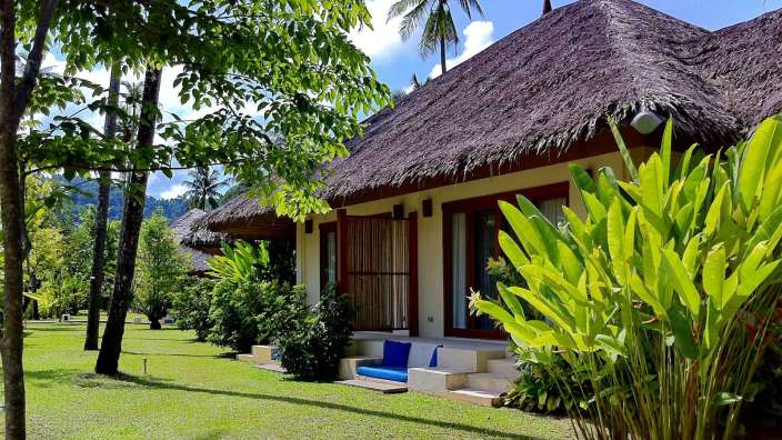 Eine Reihe von Hütten mit Strohdach stehen nebeneinander