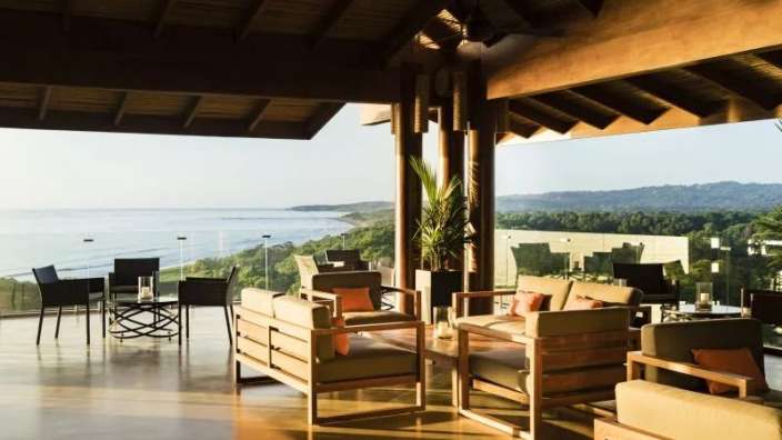 Ein Wohnzimmer mit Möbeln und einem Tisch mit Blick auf das Meer
