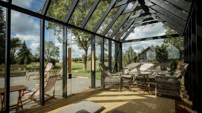 Ein Wohnzimmer mit vielen Fenstern und Möbeln