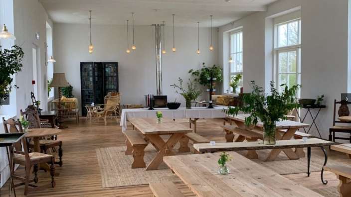 Ein großer Raum mit vielen Holztischen und Bänken