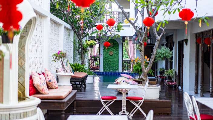 Ein kleiner Raum mit Tischen und Stühlen neben einem Pool