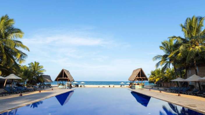 Ein großer blauer Pool führt zum Strand