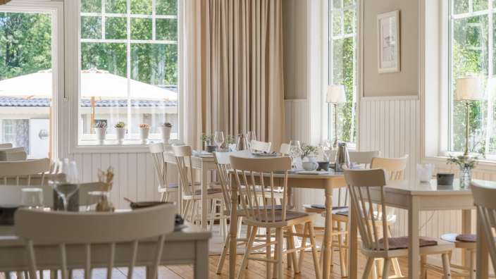 Ein Esszimmer mit vielen Tischen und Stühlen