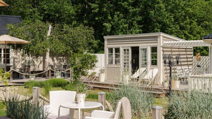 Ein kleines Haus mit einem Tisch und Stühlen davor