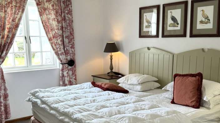 Ein Schlafzimmer mit einem Bett und drei Bildern an der Wand