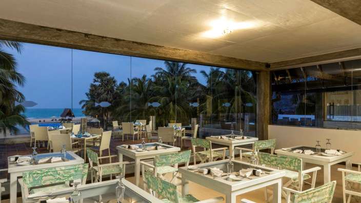 Tische und Stühle in einem Restaurant mit Blick auf den Strand