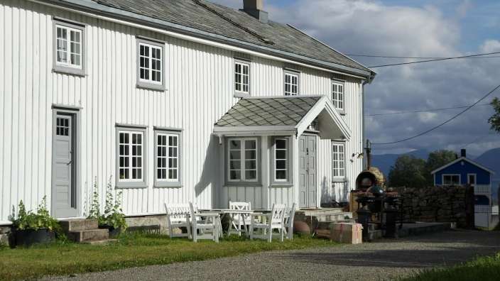 Ein weißes Haus mit einem Tisch und Stühlen vorne