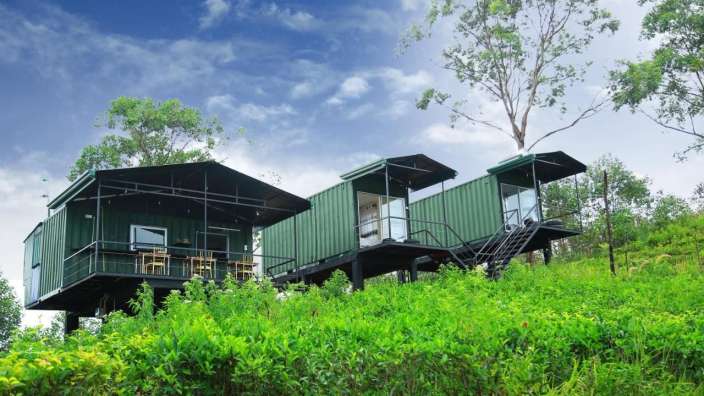 Zwei grüne Häuser stehen auf einem grünen Hügel