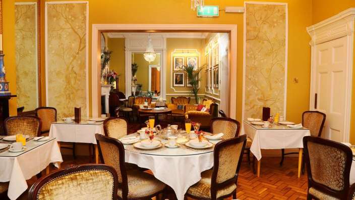 Ein Esszimmer mit vielen Tischen und Stühlen
