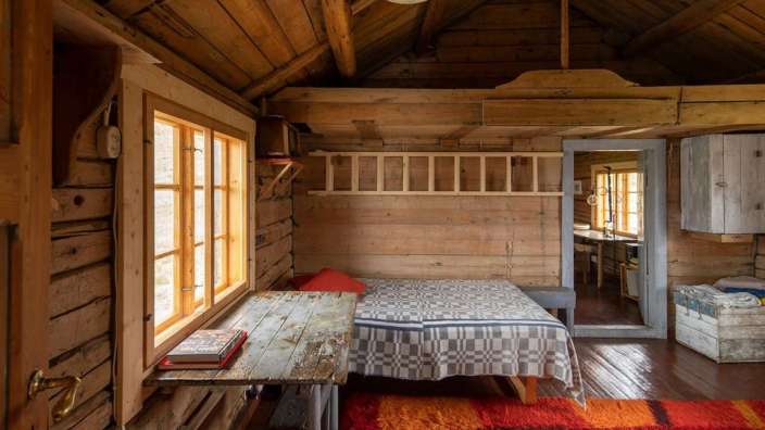 Ein Holzzimmer mit einem Bett und einem Tisch