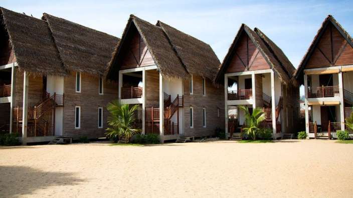 Eine Reihe von Holzhäusern mit Strohdach