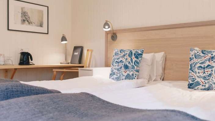 Ein Hotelzimmer mit zwei Betten und einem Schreibtisch