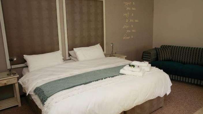 Ein Schlafzimmer mit einem Kingsize-Bett und einer Couch .