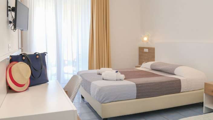 Ein Hotelzimmer mit einem Bett und einem Fernseher