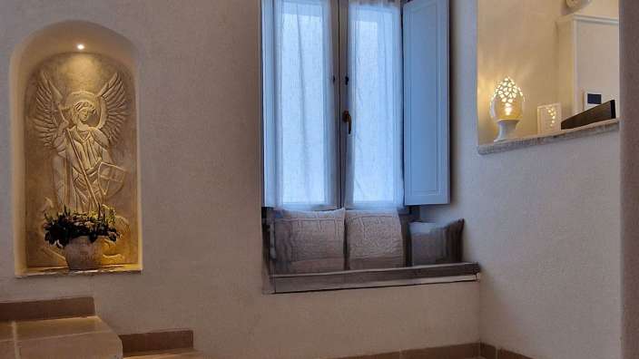 Eine Statue eines Engels steht neben einem Fenster