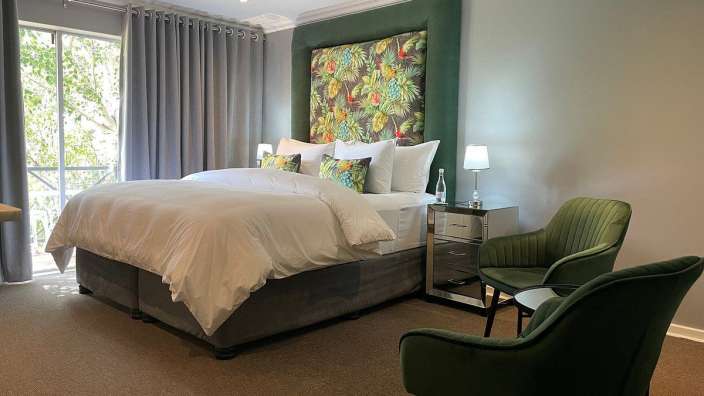 Ein Schlafzimmer mit einem großen Bett und zwei Stühlen