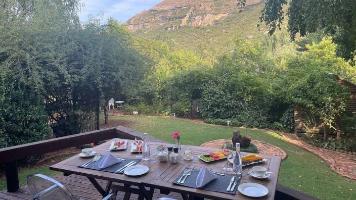 Ein Tisch mit Tellern und Gläsern auf einem Deck mit einem Berg im Hintergrund