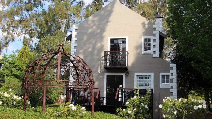 Ein kleines Haus mit einem Balkon und weißen Fenstern