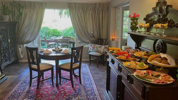 Ein Esszimmer mit einem Tisch und Stühlen und einem Buffet