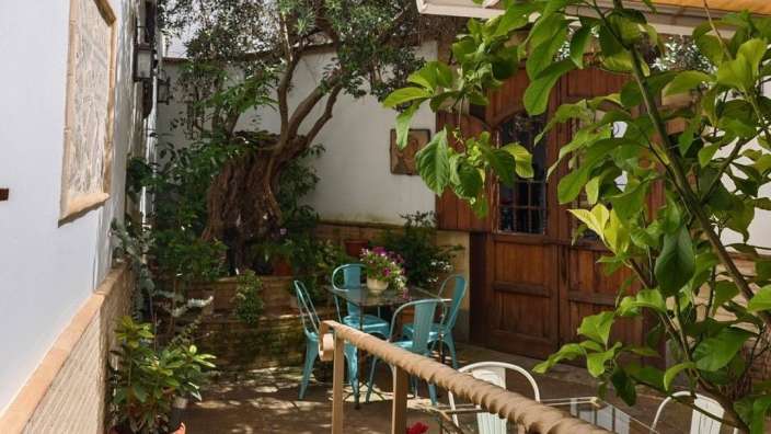 Eine Terrasse mit einem Tisch und Stühlen und einem Baum